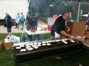 A volunteer cooks up burgers at last year's Convoy of Hope event in French Hill. (Photo/submitted)
