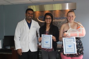 Dr. Sanjiv Nehra of Dental Associates of Marlborough presents scholarships to Himandri Patel (center) and Emily Whapham. (Photo/submitted)