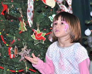 After getting her face painted, Violet Thomas checks out the trees at last year’s festival. File photo/Ed Karvoski Jr. 