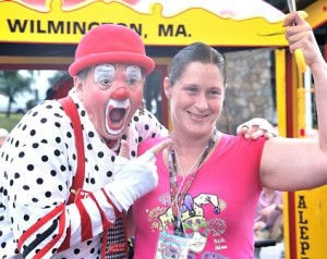 Do-No of the Aleppo Shriners' Clowns shares an umbrella with Sheri Richardson as her friend takes a photo of them.