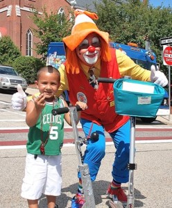 Jayden Lopez, 4, and Joee O of the Aleppo Shriners' Clowns compare their scooters.