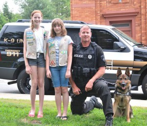 Gathered outside the Marlborough Public Library are (l to r) Girl Scout Cadettes Emma Cohen and Laura Nelson with Officer Ken McKenzie and Kaiser.