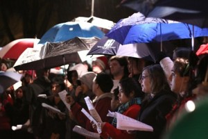 Members of the Marlborough High School Mixed Chorus perform under umbrellas,