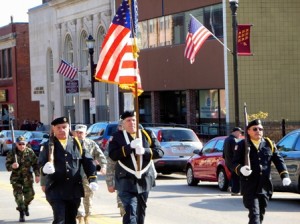 Tim Phillipo, captain of the Color Guard for the American Legion, flag bearer Dennis Digou, and veteran Donald Edward march together along the parade route. 