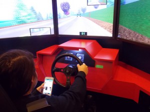 Ava Desautels, a junior at Assabet Valley Regional Technical High School, uses her cell phone during the driving simulation.