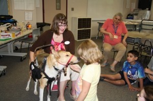Madison Harper gets a kiss from Asha while Hartness talks about the rigorous training service dogs go through.  