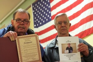 Edward Donnelly (left) displays Northborough's Purple Heart proclamation as Edward Bombard (right) holds a picture of his son, Tim Bombard, who is a Purple Heart recipient. (Photo/John Swinconeck)