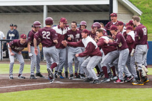 Algonquin’s Justin O’Connell (#22) is greeted by teammates at home plate after hitting a home run in the ninth inning. 
