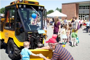 Kids of all ages wait their turns to explore the many big trucks and machines.