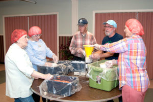 Community members are busy preparing food packages. Photos/submitted