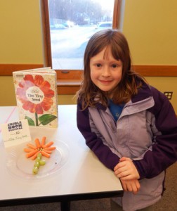 Second grader Julia Mikolajczak with her edible book, “The Tiny Seed