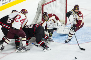 Goalie Michael Tascione (#1) and defenseman Dennis Achkinazi (#25) scramble for a loose puck in front of the goal.