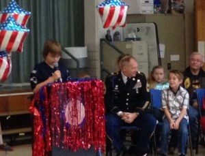 Fourth-grader Connor Veitch introduces the veterans in attendance, including his father Don (center), who is sitting with his twin brother Dylan.