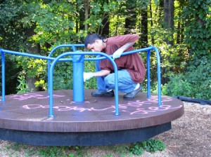 Inmate Bruce Irene attempts to clean graffiti off a piece of playground equipment. 