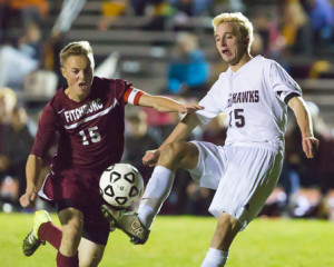 Algonquin’s Max Michaud (#15 white) and Fitchburg’s Ben Phaneuf (#15 red) battle for the ball.