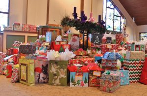Some of the collected presents stacked in front the altar of St. Rose of Lima parish. (Photos/Kelly Slovin)