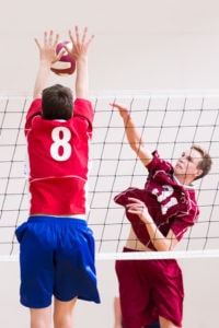Algonquin’s Brooks Gingrich spikes the ball as Natick’s Mason Bailey attempts to block.