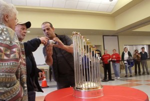 Spiro Trachanas, right, after photographing Bob and Dorris Hobbs with the 2013 World Series trophy.