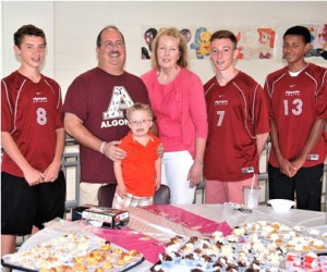 Gathered at a display of treats are (front) Liam Fitzgerald, 7, (back, l to r) Cam Marcovlier of ARHS junior varsity soccer; Rob Berger, president of ARHS Athletic Boosters Club; Mary Beth Benison, owner of CocoBeni Confections; with soccer players Evangelos Baltas and Gavin Frasier-Felix.