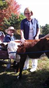 LPN Leila Isomaki pets a calf while Beaumont resident Jack Kapish looks on.