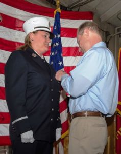 Tom Crippen pins the lieutenant shield on his wife. 