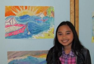 Fourth grader Ellie Ouano stands by her artwork inspired by Marguerite E. Peaslee’s work during Peaslee’s school’s Northborough’s 250th year school event.