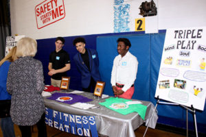 At the club’s 75th anniversary celebration, (l to r) Tyler Lechman, Daisjaugn Jermaine Bass, and Sincere Redd, staff members at the Boys & Girls Clubs of MetroWest, speak with guests about the Sports, Fitness & Recreation programs