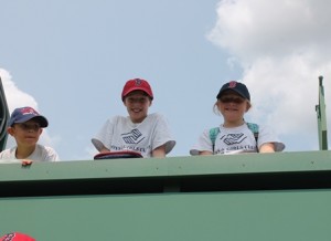 (l to r) Vinny Martino, Gavin Whitman and Fiona Lee, members of the Boys and Girls Clubs of MetroWest's Hudson division peer out over Fenway's Green Monster.