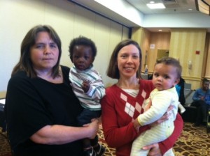 Julie Stanwood and Catherine Rhodes of  Friends of Families in Transition, hold young guests at the dinner. 