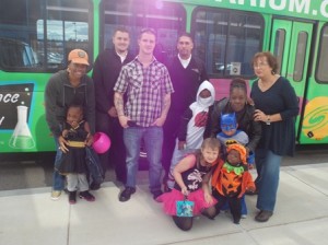 Barbara Clifford, president of the Corridor Nine Area Chamber of Commerce (right), stands with the two WRTA drivers and some of the local families attending the Apple Tree Arts event Oct. 27.  