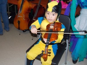 This budding musician enjoys trying out an instrument at the 2013 party.  File photo/Bonnie Adams 