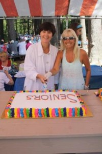 Representative Carolyn Dykema (left) and CherylAnn Lambert Walsh cut the cake.