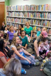 A crowd of parents and children listen to stories being read by Sherri Galego from the U.Fund Start U. Reading Organization as they anxiously await the arrival of Elmo. 