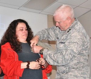 The Commander's Award for Public Service medal is pinned on Lisa Braccio by Maj. Gen. L. Scott Rice.