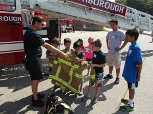 Campers at Finn School learn about the gear that every firefighter wears while on the job. (Photo/Gregory Arnold)