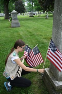 Maggie Shoemaker, of Southborough Girl Scout Troop 72807, honors veterans by placing American flags on graves of those who have served. 