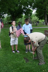Troop 1 Southborough Scoutmaster, Rik Kerstens, helps his troop in ensuring that every veteran's gravestone has an American flag placed by it. 