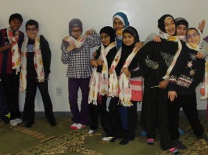 Al-Hamra Academy students display the scarves they made. (Photo/submitted)
