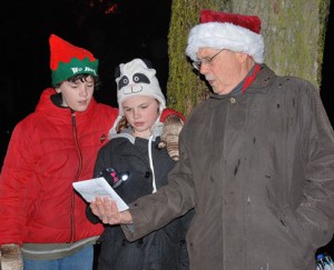 Terry Crouse, 12, his sister Vanessa, 10, and their grandfather Pete Murphy sing “Joy to the World.”