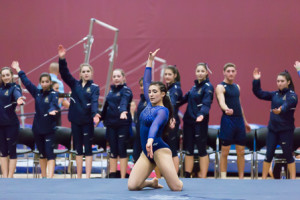 Katrina DiGiacomo is cheered on by her teammates as she performs her floor exercise,
