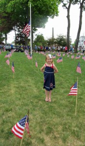 Mina Bradley, who just turned 5, is surrounded by a sea of flags as she waits for the parade to start.