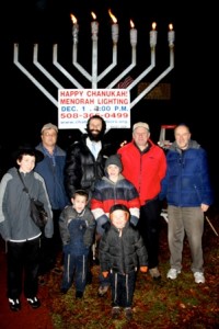 Moishe, 13, Selectman Maurice DePalo, Rabbi Michoel Green, Selectman John Lebeaux, Gene Jena, Shmuli, 5, Levi, 9, and Shalom, 3, pose for a photo at the lighting. 