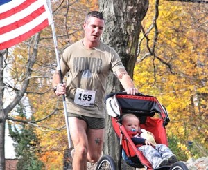 Seamus Shanley approaches the finish line with his son Quinn, 1, in this year’s Veterans Memorial 5K Road Race in Shrewsbury to benefit Veterans Inc. File photo/Ed Karvoski Jr. 