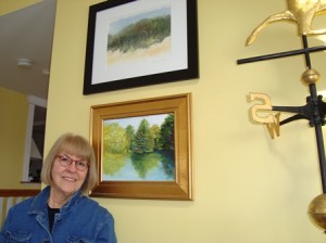 Shrewsbury artist Nancy Allen stands in her home next to a creation that she painted of the scenery at Wood Park in Hudson using suggestions from her fellow participants in the 