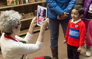 Shrewsbury Public Library Director Ellen Dolan uses an iPad to photograph a young man waiting to see Santa.