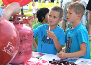Eight-year-old friends Adam Karmelek and Matthias Dlouhy get helium balloons and glow sticks at the Fay School table. Photos/Ed Karvoski Jr.