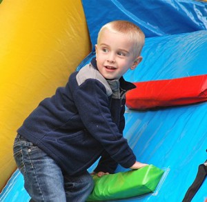 Liam Vernon, 3, climbs up an inflatable slide.