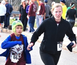 Arthur Tan, 7, races toward the finish line with his aunt, Rebecca Christianson.