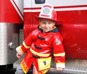After marching in the parade, Trevor Kurtz, 3, takes a break at a fire engine.