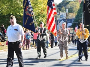 Commander Steve Whynot of VFW Post 3276 (left) leads a color guard of local military veterans. 